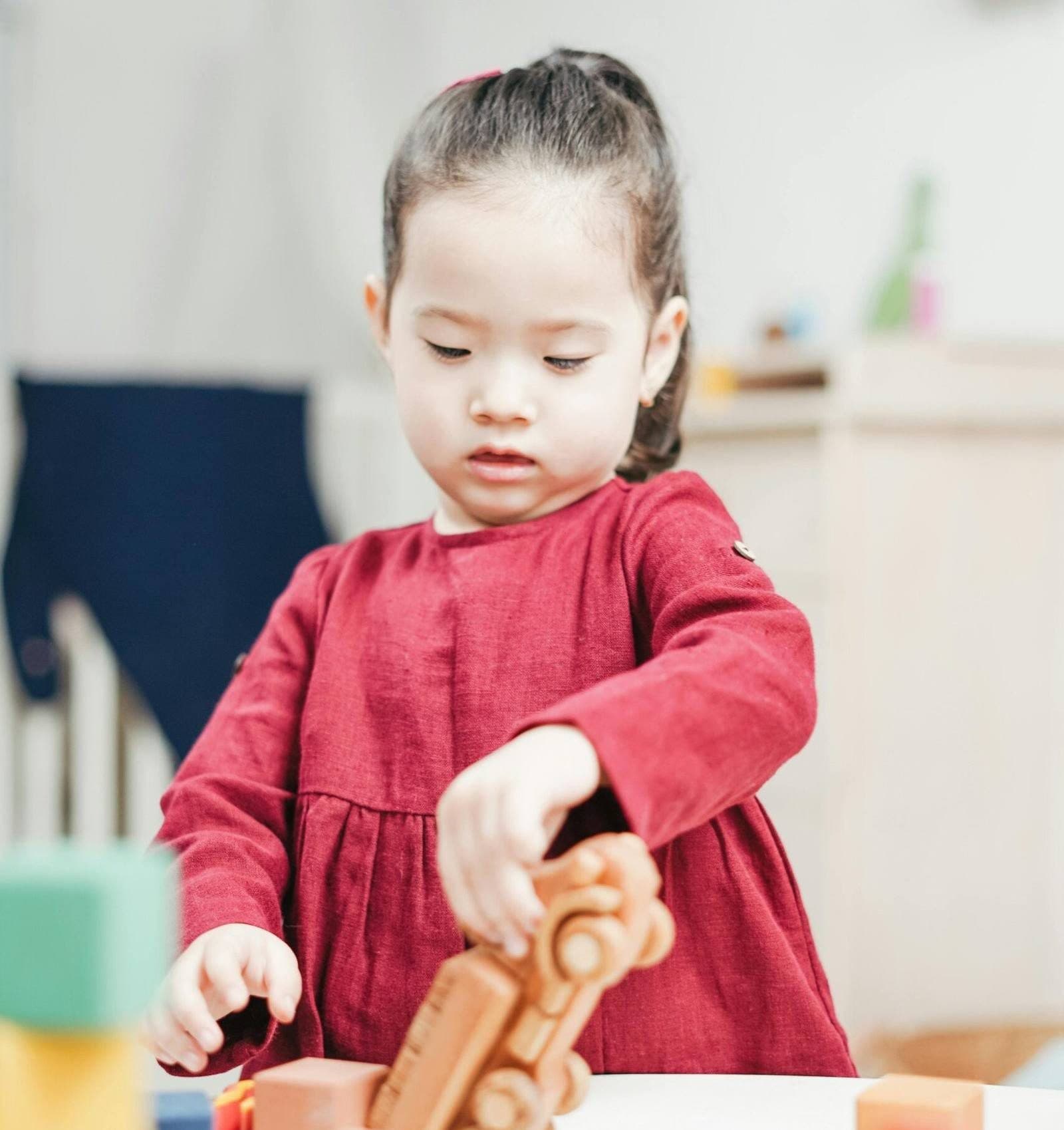 A young girl playing with building blocks
