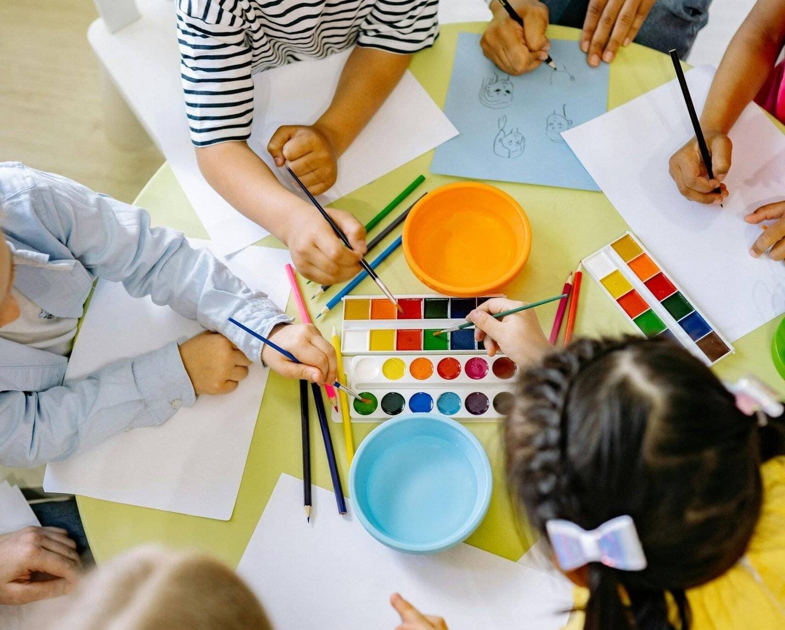 Children painting together at a preschool table